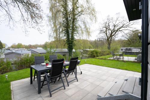 a patio with a table and chairs in a yard at Ostseecamp Ferienhaus "StrandPerle" in Scharbeutz