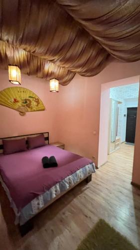 una camera da letto con un grande letto con lenzuola viola di 10/8 Kotliarska Moisha House a Lviv