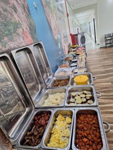 a buffet line with trays of different types of food at Hotel Reserva do Xingó in Piranhas