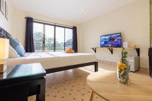 a hotel room with a bed and a table at Club22 Kamala Suites, Kamala Beach in Kamala Beach