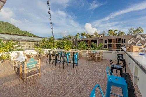 a patio with tables and chairs on top of a building at Club22 Kamala Suites, Kamala Beach in Kamala Beach