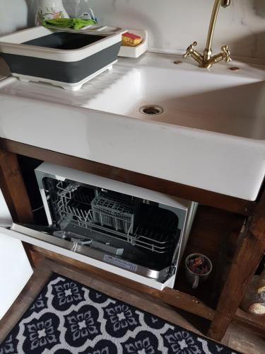 - un comptoir de cuisine avec un lave-vaisselle ouvert sous un évier dans l'établissement La Pensine du célèbre sorcier, à Bourogne