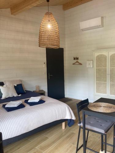 une chambre avec un lit, une table et une lampe dans l'établissement Les ptits nids du Lac, à Lacanau