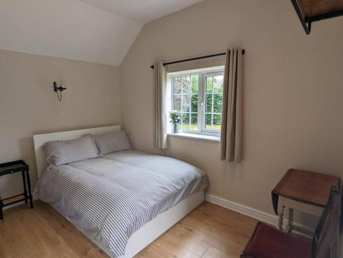 a small bedroom with a bed and a window at The Annexe at Entry House in Quadring