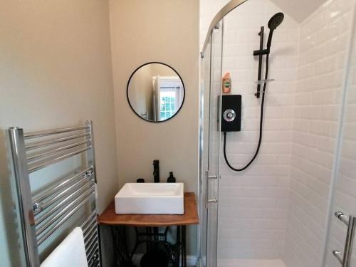 a bathroom with a sink and a shower with a mirror at The Annexe at Entry House in Quadring