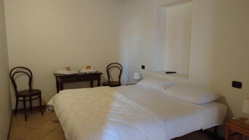 a bedroom with a bed and two chairs and a table at B&B Agora' in Gardone Riviera
