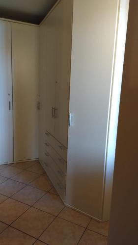 an empty room with white cabinets and a tile floor at AGORÀ suite in Gardone Riviera