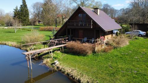 een blokhut met een brug over een rivier bij Mežvītoli in Mercendarbe