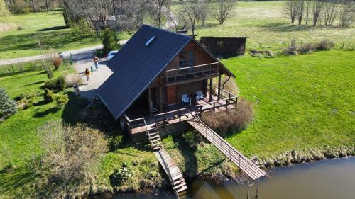 uma casa com um telhado azul no topo de um rio em Mežvītoli em Mercendarbe