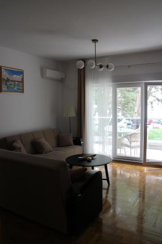 een woonkamer met een bank en een tafel bij Apartman Mama in Trebinje