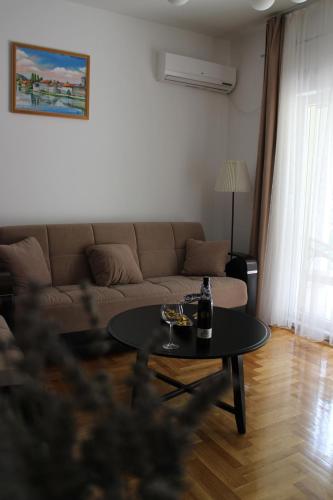 een woonkamer met een bank en een tafel bij Apartman Mama in Trebinje