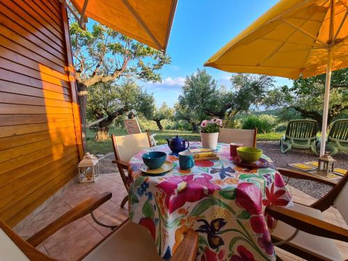 einen Tisch und Stühle auf einer Terrasse mit Sonnenschirm in der Unterkunft Ktirakia Studios in Gythio