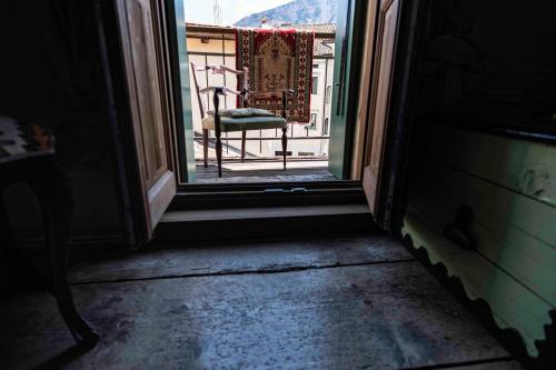 an open door with a chair outside of a window at La Maisonette in Feltre