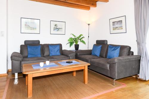 a living room with two couches and a coffee table at Ferienwohnungen im Haus Nordlichter in Holtgast