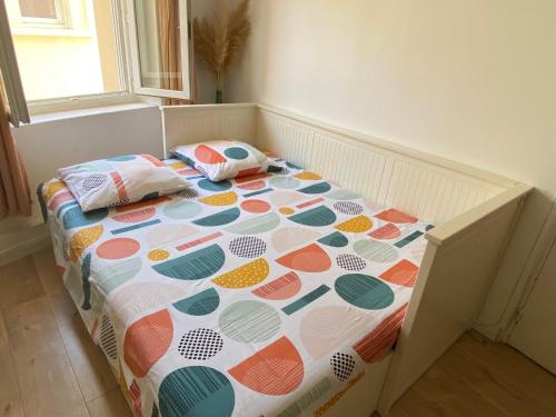 - un lit avec une couverture en point de polka et des oreillers dans l'établissement Studio ROMY les pieds dans l'eau 10 m de la mer, à La Seyne-sur-Mer