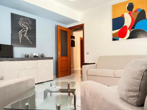 uma sala de estar com um sofá e uma mesa de vidro em La Casa di Wioletta em Barcellona Pozzo di Gotto
