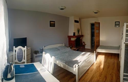 a bedroom with a white bed and a fireplace at Zator Sleepover in Zator