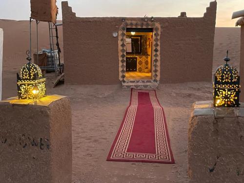 a red carpet leading to a door in a building at Desert Erg Chegaga Camp in El Gouera