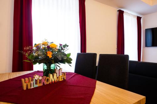 a dining room table with a vase of flowers on it at Gasthof & Hotel Bichler in Emmering