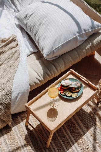 a tray of food on a table next to a bed at Czorsztyn Glamp in Maniowy
