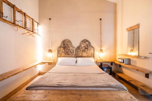 a bedroom with a bed with a headboard and two lamps at Agriturismo Sweet Cottage in Marina di Grosseto