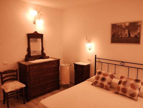 a bedroom with a bed and a dresser and a mirror at La Casina di Nonna Giulia in Castiglione dʼOrcia