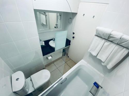 a white bathroom with a toilet and a sink at Mandy's kaliva Club Mykonos in Langebaan