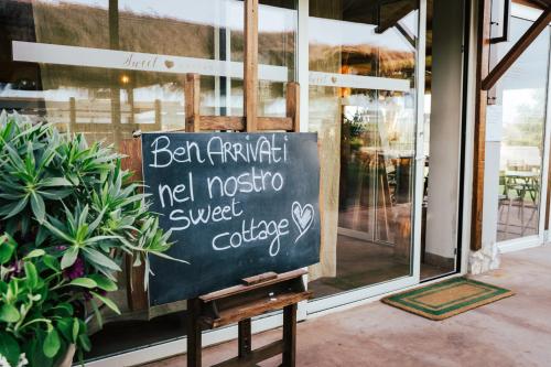 a chalkboard sign sitting in front of a store window at Agriturismo Sweet Cottage in Marina di Grosseto