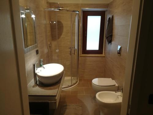 ein Bad mit einem Waschbecken, einem WC und einer Dusche in der Unterkunft Affittacamere Stazione 24 in Cervignano del Friuli