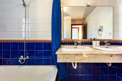 łazienka z dwiema umywalkami, wanną i lustrem w obiekcie Villa Sea Sounds w Corralejo