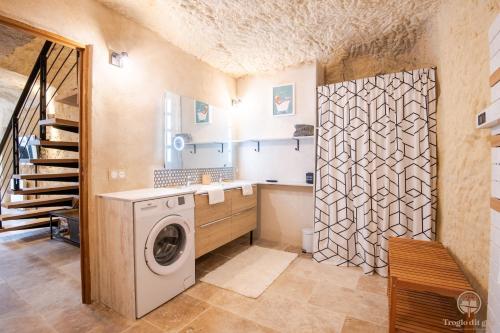 y baño con lavadora y ducha. en Troglo Dit Gîte 4* proche d'Amboise, en Nazelles