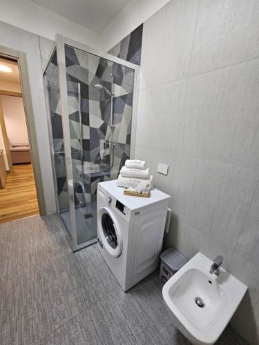 a bathroom with a washing machine and a sink at appartamento la chiocciola in Cavallino-Treporti