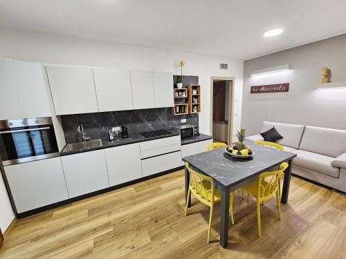 una cucina e un soggiorno con tavolo e divano di appartamento la chiocciola a Cavallino-Treporti