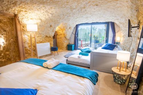 1 dormitorio con 2 camas y ventana en Troglo Dit Gîte 4* proche d'Amboise, en Nazelles