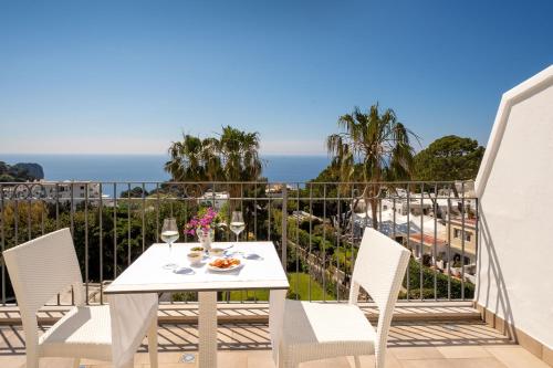 a table and chairs on a balcony with a view of the ocean at Hotel Syrene in Capri