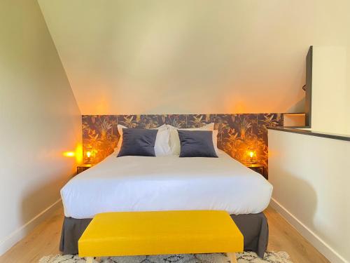 - une chambre avec un grand lit et un banc jaune dans l'établissement Le Criollo, à Apremont