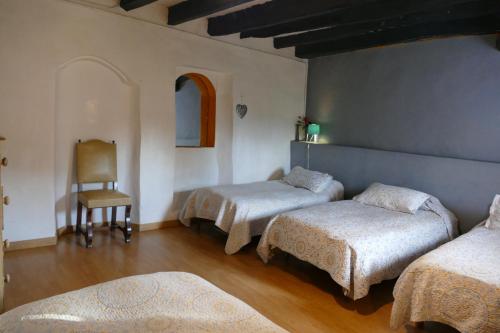 a room with three beds and a chair at APARTAMENTO GIRASOL in Argelaguer