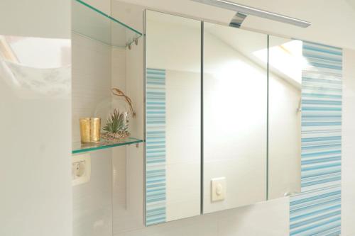 a glass cabinet in a bathroom with blue stripes at Apartment Sea view in Kali