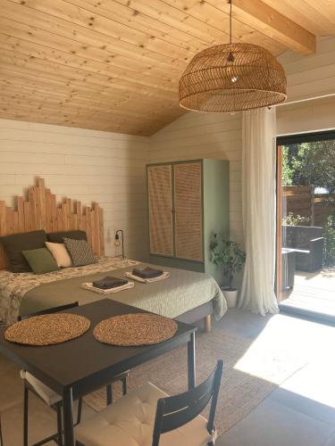 une chambre avec un lit, une table et des chaises dans l'établissement Les ptits nids du Lac, à Lacanau