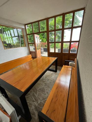 a room with two wooden tables and windows at Cesargradska klet in Tuhelj