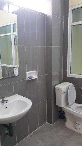 La salle de bains est pourvue d'un lavabo, de toilettes et d'un miroir. dans l'établissement บ้านOrman, à Chumpon