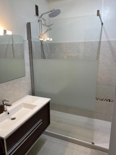 une salle de bain blanche avec un lavabo et une douche dans l'établissement Le Minerve, à Menton