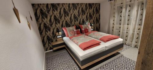 a bedroom with a bed with red pillows on it at Renatas Ferienwohnung Wohnung David in Sasbachwalden