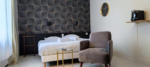 um quarto com uma cama e uma cadeira em Guest Home location em Néris-les-Bains