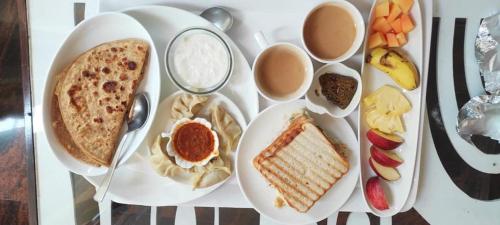 uma mesa coberta com pratos de comida e sobremesas em Ratna Hotel & Banquet em Muzaffarpur