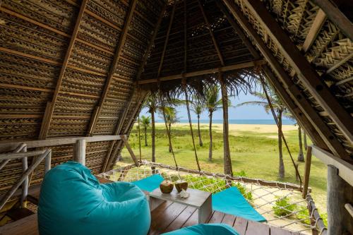 a room with blue chairs and a table in a hut at Elements Beach & Nature Resort in Kalpitiya
