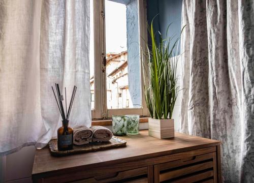 a wooden table with a window and plants on it at La Maisonette in Feltre