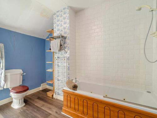 een badkamer met een bad en een toilet bij Lilac Cottage in Grosmont