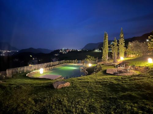 a swimming pool in a park at night at Burgunderhof in Montagna