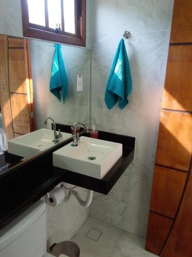 a bathroom with a white sink and a mirror at Pousada Reis Guarujá in Guarujá